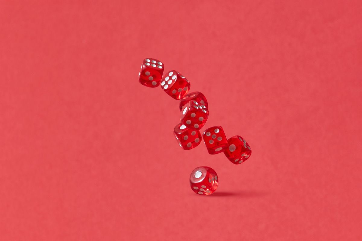 Red dice scattered across a bright table at game night