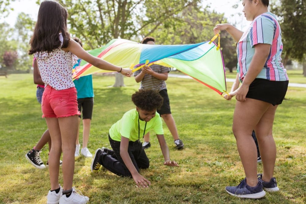 Children laughing while playing a parachute game together