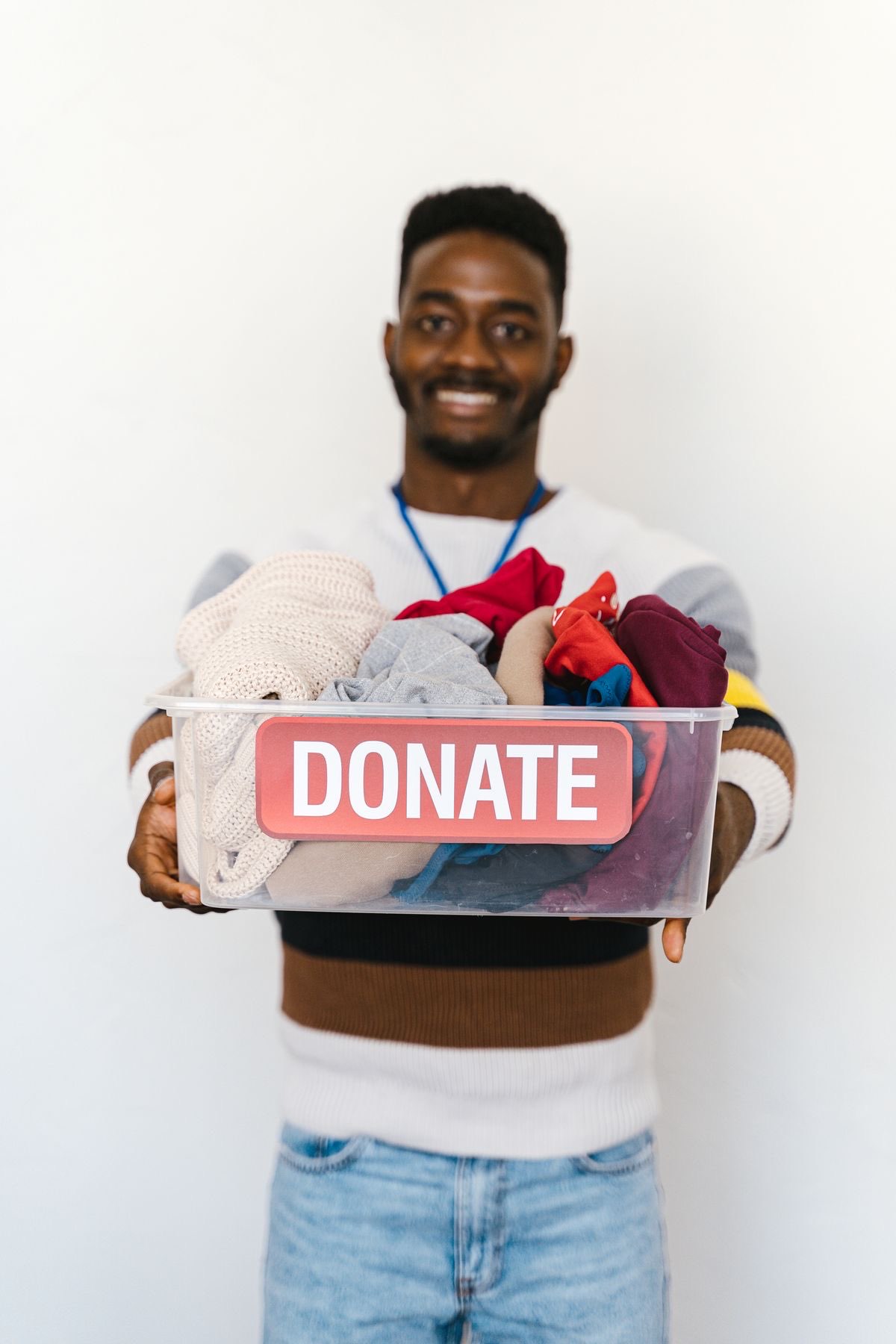 Volunteer smiling while holding a box marked donate