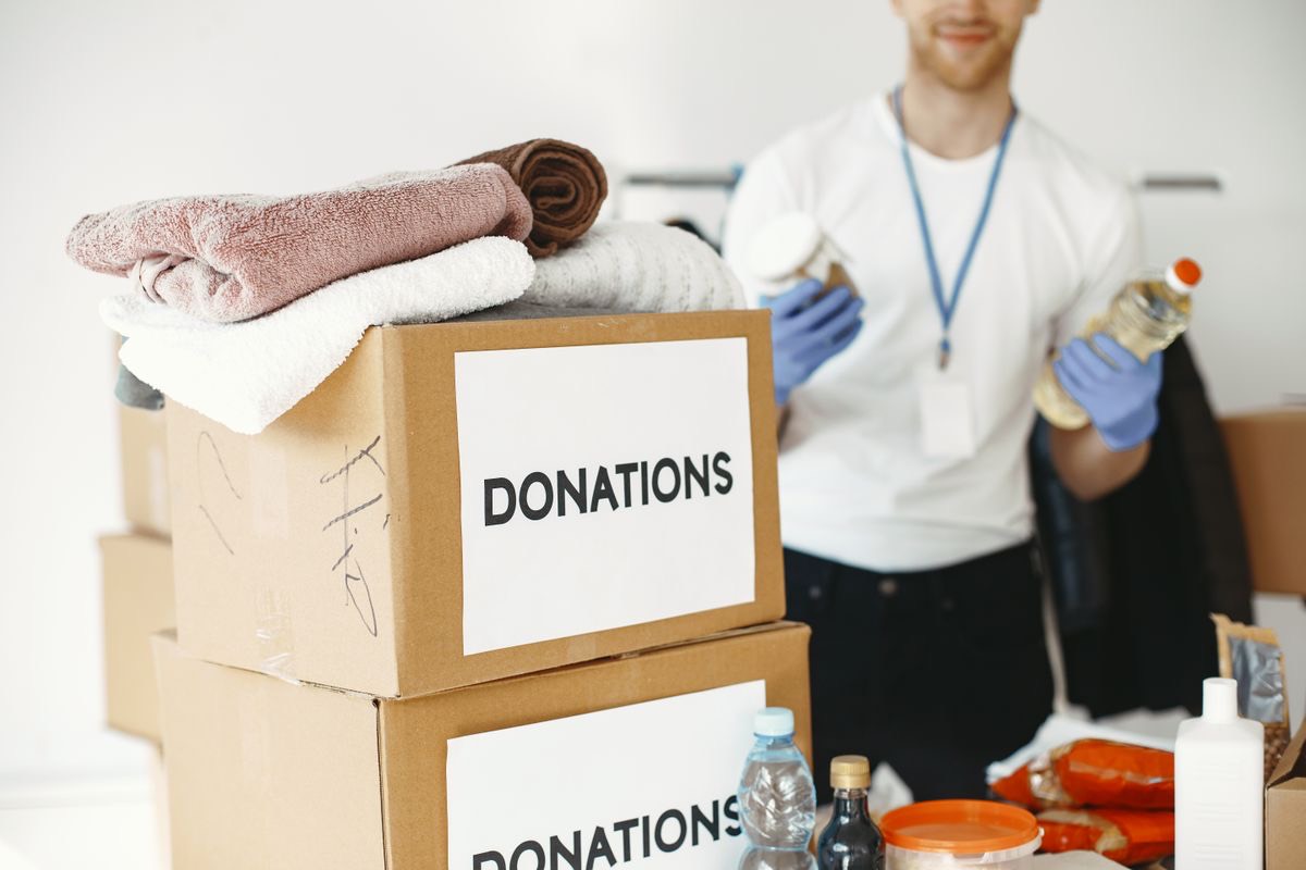 Volunteer sorting boxes of community donations